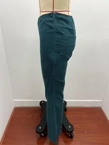 Side view detail of women corduroy flare pants, solid high waist casual trousers in deep green.