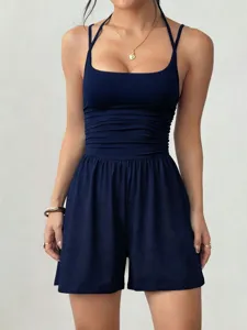 Detail shot of the navy blue halter romper featuring square neck and pleated waist design.