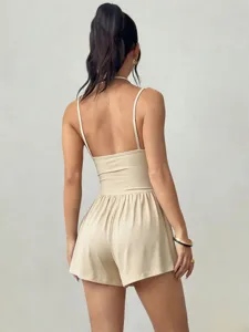 Vue arrière d'une combishort beige à licou, mettant en valeur la coupe ajustée et le dos nu.