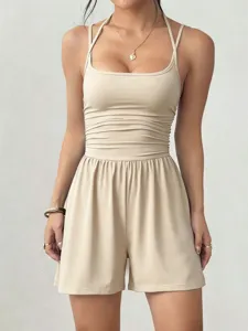 Beige halter neck ruched romper featuring fitted bodice and loose shorts for summer wear.