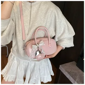 Sweet pink bowling handbag detail showcasing cute lace bow and delicate pendant design.