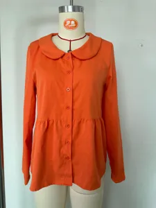 Orange long sleeve blouse featuring peter pan collar, front button closure and peplum waist detail.