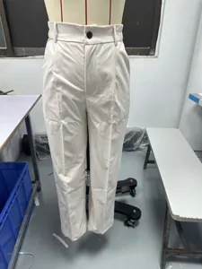 Dettaglio dei pantaloni eleganti da donna a vita alta con taglio dritto in beige.