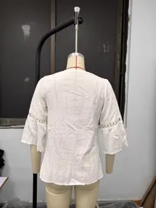Detalle posterior de la blusa de lino blanco con un delicado ribete de encaje fino.