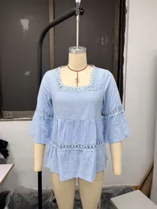Vista detallada de blusa de mezcla de lino azul claro con cuello cuadrado y encaje