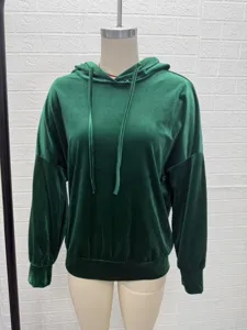 Detailed view of the dark green velvet hoodie featuring a cozy drawstring hood and cuffs.