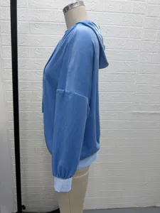 Detailed side view of light blue velour long sleeve hoodie with hood and drawstring.