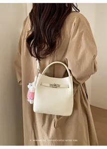 Detailaufnahme der stilvollen Leder Eimer Tasche mit Metallverschluss und Bär Anhänger.