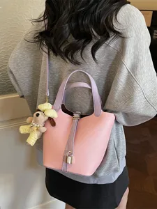 Stylish pink soft leather bucket bag with metal lock and cute doll pendant for women