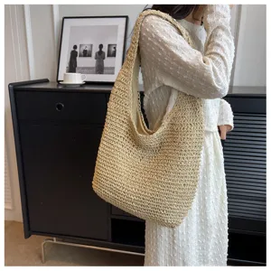 Borsa a tracolla in paglia beige vista di dettaglio con grande capacità stile estivo.