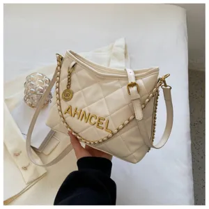 White quilted shoulder bag detail featuring gold chain strap and stylish metallic lettering.