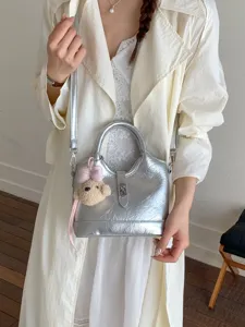 Borsa a mano metallizzata argento con ciondolo orsetto, elegante borsa a tracolla da donna.