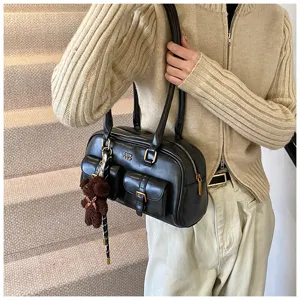 Detailansicht der vintage retro schwarzen Umhängetasche mit Taschen und süßem Bärenanhänger.
