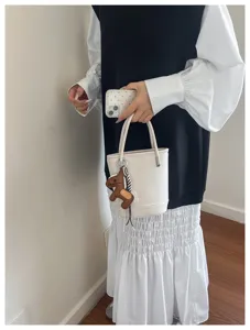 Detailed view of the stylish white litchi pattern bucket bag with charm for daily use.