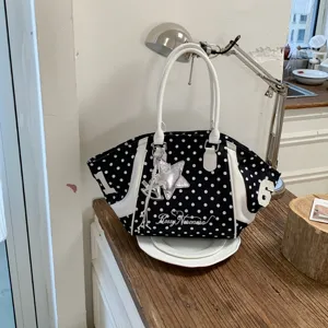 Detail view of black and white polka dot tote handbag, stylish large capacity shoulder bag.