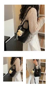 Detail view of the black bucket bag with plush charm, showcasing versatile daily styling.