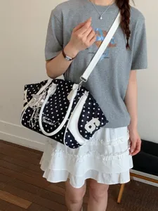 Fashionable large capacity polka dot shoulder bag for women, commuter crossbody and tote handbag.