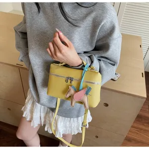 Bolso de mano tipo caja de cuero amarillo elegante con bonito colgante de pegaso y correa.