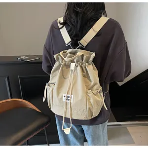 Detailed view of the casual canvas drawstring backpack worn by model, showing back design.