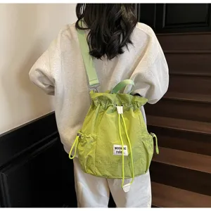 Green casual canvas drawstring backpack detail, lightweight daily school daypack, adjustable strap.