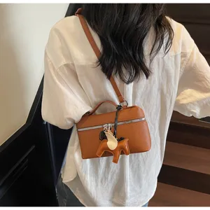 Bolso bandolera tipo caja de cuero marrón con asa, cremallera plateada y bonito colgante de caballo.