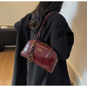 Dark red patent leather underarm shoulder bag detail, vintage pillow bag craftsmanship showcase.