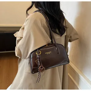Retro brown patent leather shoulder bag detail, stylish autumn commute pillow handbag design.
