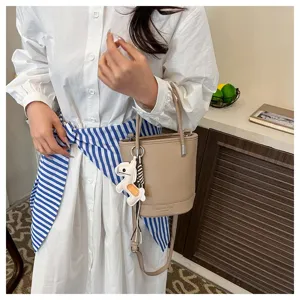 Chic litchi pattern bucket bag with cute horse charm, versatile crossbody for women spring.