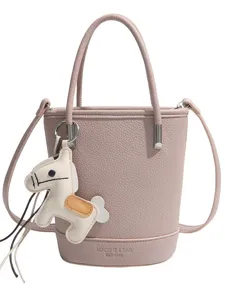 Pink litchi grain leather bucket bag with top handle and cute horse charm main view