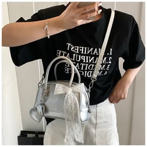 Trendy silver bowling handbag with elegant white lace bow and heart charm for women fashion.
