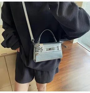 Silver metallic top handle bag with shoulder strap and balloon dog charm for women