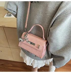 Pink textured women handbag with top handle shoulder strap and silver metal charm pendant stylish
