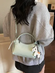 Light green crescent handbag with horse charm, stylish casual crossbody bag for women.