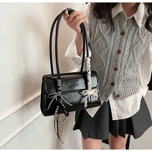 Detailed close-up view of elegant black PU leather shoulder bag with cute bow and beads.