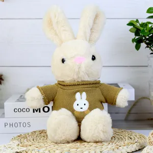 Detailed close-up of a cute dressed rabbit plush toy wearing a brown knitted sweater.