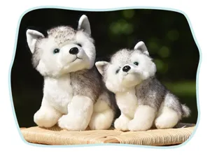 Close-up shot of two adorable realistic plush husky stuffed dog toys sitting together outdoors.