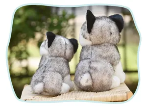 Detail view of two cute simulated husky plush toys sitting on a woven stool outdoors.