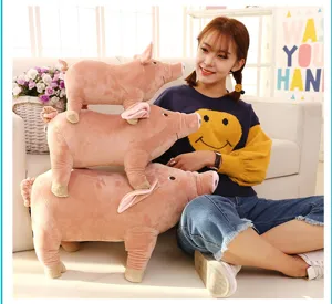 Close-up detail of cute pink plush pig stuffed animals in a cozy living room scene setting.