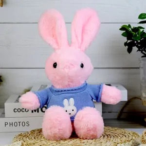 Cute pink plush rabbit toy with blue knitted sweater, detailed close-up shot for kids gift.