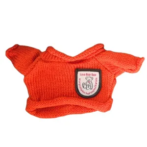 Orange knitted sweater for teddy bear dolls, cute mini pullover with bear patch graphic.