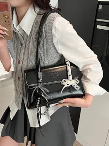 Stylish black shoulder bag for women, trendy underarm purse with elegant bow and pearl charms.