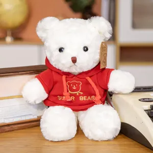 Detailed shot of cute white plush teddy bear wearing a red hoodie toy close-up view
