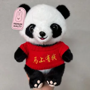 Close-up detail of a cute plush panda toy wearing a red knitted sweater with embroidery.