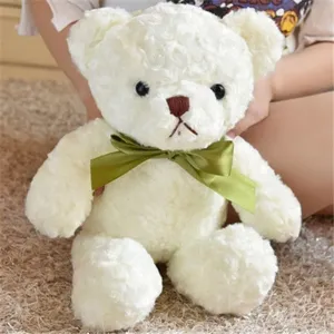 Plush teddy bear toy with green bow, soft white fabric, perfect gift for kids and parties.
