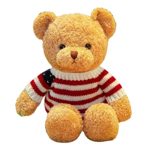 Cute plush teddy bear toy wearing a classic knit flag sweater, soft stuffed doll gift for kids.