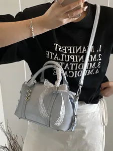 Stylish light blue shoulder handbag for women featuring elegant lace bow and heart pendant.