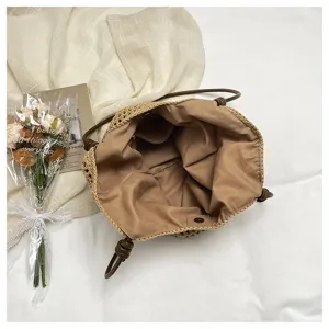 Detailed view of the woven straw tote bag with fabric lining, stylish resort style for summer.