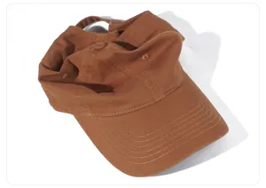 Vista detallada de la gorra de béisbol de algodón marrón, visera curva, estilo casual.