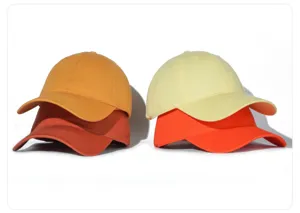 Primer plano detallado de gorras de beisbol de algodon lavado apiladas en colores calidos.