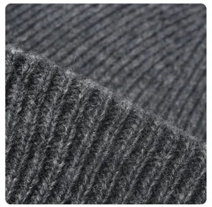 Primer plano de la textura del gorro de punto de lana gris oscuro, tejido de invierno.
